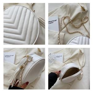 Detailed views of white quilted round crossbody bag with chain strap and fringe tassel