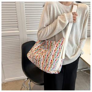 Detail of colorful woven tote bag featuring multi-color stripes and a wide strap