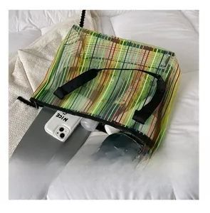 Détail montrant la grande capacité du sac fourre-tout en mesh vert fluo avec un iPad et téléphone