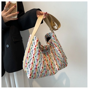 Detail of colorful woven tote bag with adjustable leather strap and interior logo tag