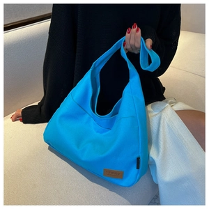 Detailed close-up of a vibrant blue canvas tote bag featuring a leather SPORT patch and strap