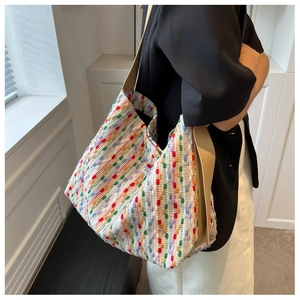 Detail view of colorful woven tote bag with large capacity and brown leather strap on shoulder