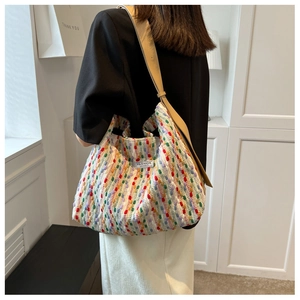 Detail of multi-colored woven tote bag with Fashion Instinct label and wide shoulder strap