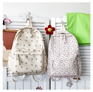 Detail of floral canvas backpacks with floral prints and braided zipper pulls for students