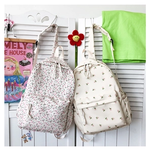 Detail of floral canvas backpacks with drawstring closure and rose embroidery accents