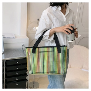 Détail du sac cabas à rayures arc-en-ciel avec des poignées en toile noire solides