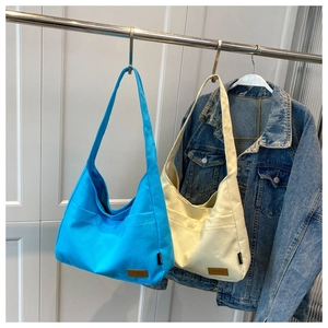 Detail of blue and white canvas tote bags showing reinforced straps and sport leather labels