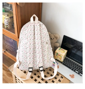 Detailed view of floral backpack side zipper pocket and beige adjustable straps