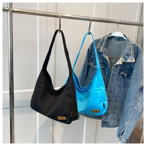 Detail view of large canvas tote bags in black and royal blue with SPORT leather patch