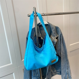 Bright blue minimalist canvas tote hobo shoulder bag with sport patch on casual hanger