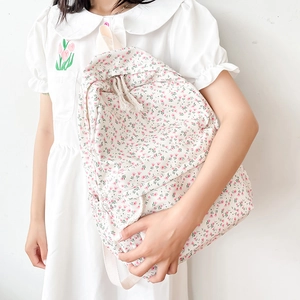 Minimalist white backpack with pink floral pattern and drawstring on model