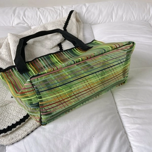 Détail de rayures arc-en-ciel sur un sac fourre-tout en maille verte transparente
