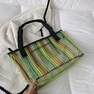 Détail du sac cabas vert transparent en PVC avec rayures colorées et anses noires tissées