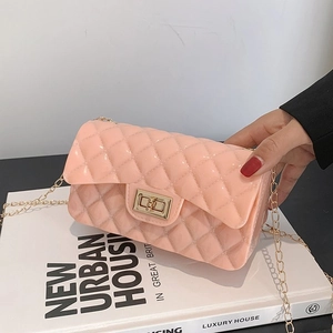 Close-up of pink quilted jelly bag with gold twist lock and metal chain strap