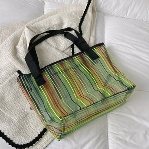 Vue macro d'un grand sac cabas en maille verte avec des rayures arc-en-ciel colorées