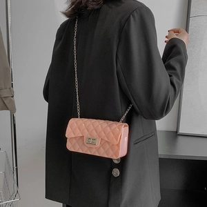 Quilted pink crossbody chain bag shown on a model wearing a black blazer jacket