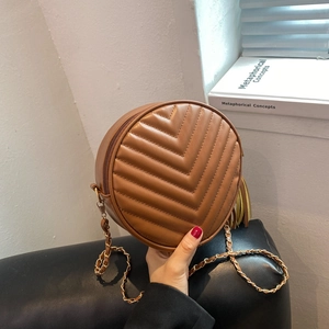 Brown circular quilted crossbody bag with chevron pattern and stylish gold chain strap