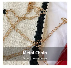 Detail shot of the golden hardware chain on a white tweed bag with black wavy lace trim