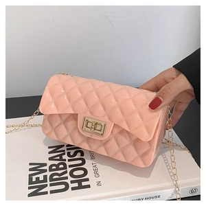 Detail of pink quilted jelly bag featuring a gold chain and metallic turn-lock closure