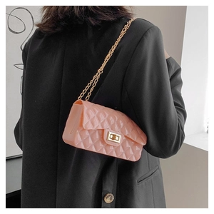 Detail of pink jelly crossbody bag featuring quilted patterns and gold chain strap