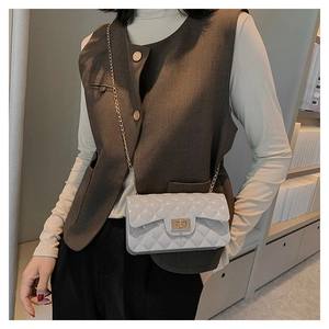 Detailed view of grey quilted leather chain bag with metallic clasp and lattice stitching