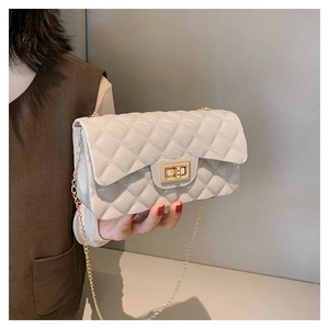 Macro shot of quilted faux leather texture and gold metal turn-lock on a chic beige bag