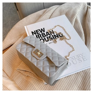 Detailed view of grey quilted leather handbag with gold twist lock and chain strap