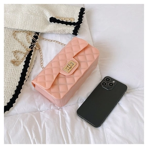 Detail view of pink quilted jelly bag with gold chain strap and metal clasp on white fabric