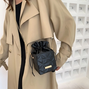 Women's black drawstring bucket bag with geometric embossed leather and gold chain