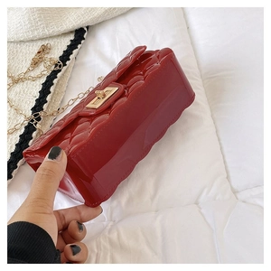 Detail view of red quilted jelly bag with gold metal twist lock and chain strap