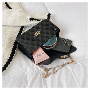 Detail showing the internal storage capacity of this black quilted chain bag with gold buckle