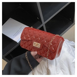 Detail of red quilted jelly bag featuring gold metal turn-lock and chain strap