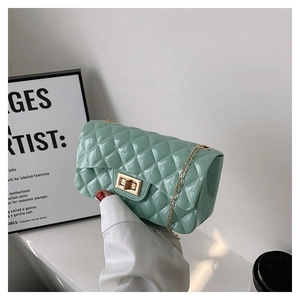 Close-up of mint green quilted leather bag with gold chain strap and metallic lock