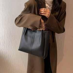 Minimalist black leather tote bag for women showing spacious interior for smartphone