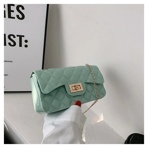 Detail of mint green quilted leather bag with glossy finish and gold metal twist lock