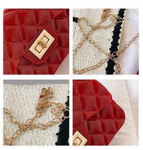 Detail of red patent leather quilted texture and gold chain strap with twist-lock