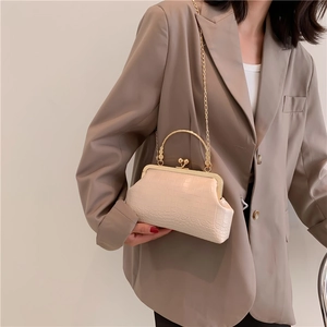 Chic beige crocodile embossed handbag with gold kiss-lock frame and chain strap