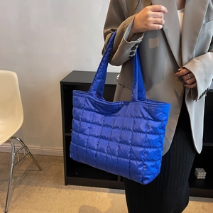 Sac fourre-tout matelassé en nylon bleu Klein avec texture rembourrée porté à l'épaule