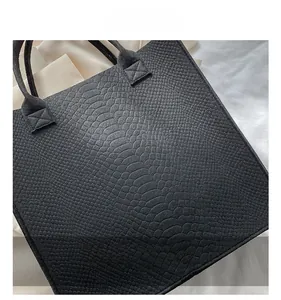 Close-up of black crocodile embossed felt tote bag showing detailed scale texture and stitching
