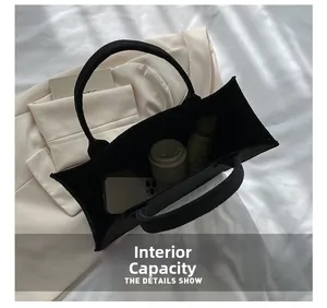 Top view of spacious black felt tote bag interior filled with daily essentials