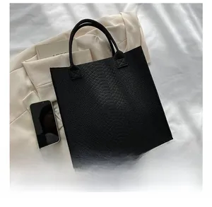 Detailed comparison of the black crocodile pattern tote bag size with a mobile phone