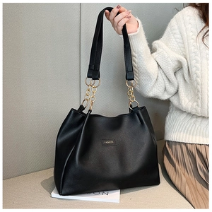 Dettaglio della grande borsa tote in pelle PU nera con catena dorata e logo fashion