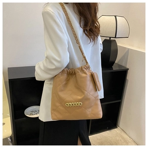 Detail of camel quilted leather bucket bag with gold chain and drawstring closure