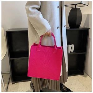 Detail of rose red felt tote bag with snake skin pattern texture and minimalist square design