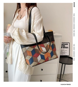 Detailed view of large tote bag with colorful geometric patchwork design and black leather trim