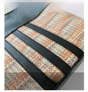 Close-up of textured woven fabric and black lychee grain leather stitching on bag
