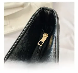 Close-up of golden square metal zipper and lychee grain leather on large shoulder bag