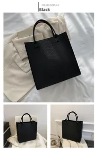 Detail showing high-quality black faux leather tote with elegant crocodile pattern embossing