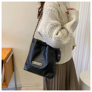 Quilted black leather bucket bag with gold chain strap and mini coin pouch accessory