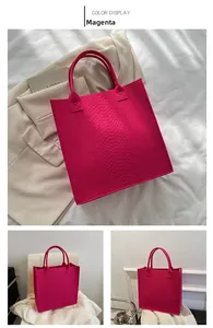 Detail of rose red felt tote bag with premium crocodile embossed texture and leather handles